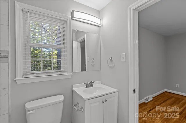 a bathroom with a toilet a sink a shower and a window