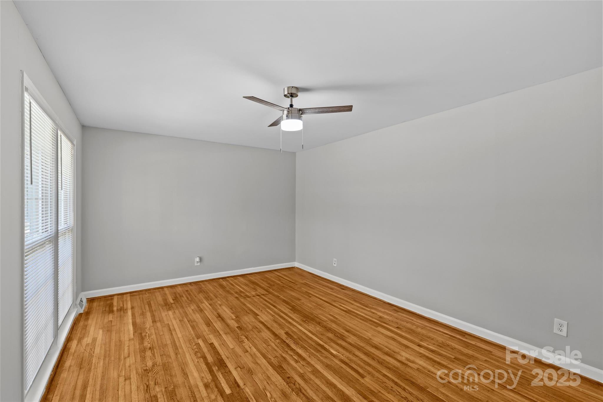 8341 Reedy Creek Road Charlotte, NC 28215 - Photo 7 of 40 a view of a room with wooden floor and a ceiling fan