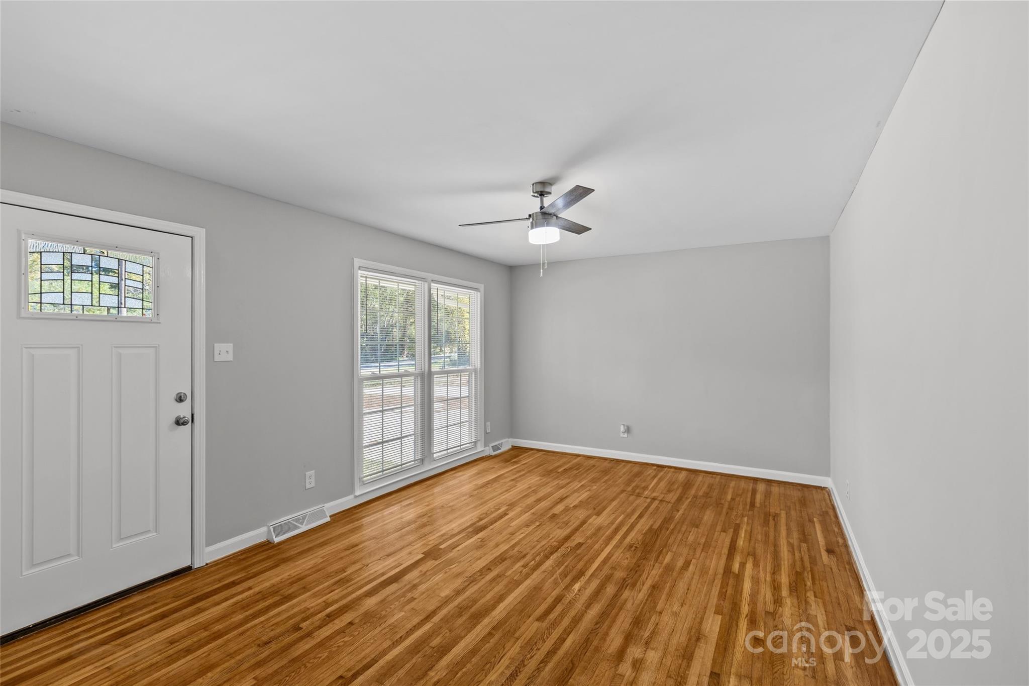 8341 Reedy Creek Road Charlotte, NC 28215 - Photo 9 of 40 a view of an empty room with wooden floor and a window