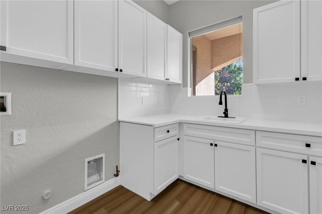 2805 Proust Court Henderson, NV 89044 - Photo 33 of 43 Laundry area with dark wood-type flooring, visible vents, gas dryer hookup, a sink, and cabinet space