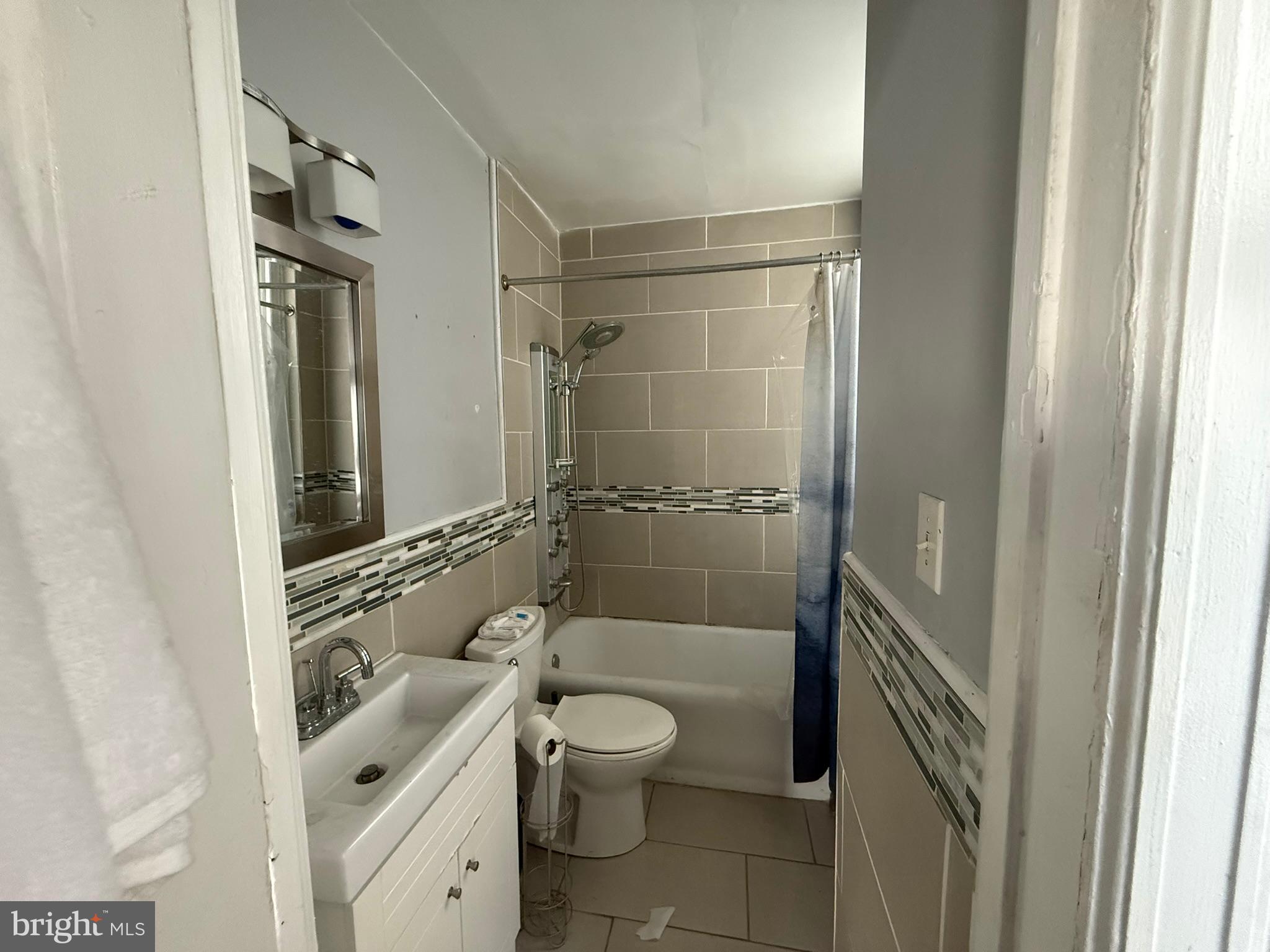 1324 Locust Street, Unit 512 Philadelphia, PA 19107 - Photo 13 of 14 a bathroom with a granite countertop sink toilet a mirror and shower