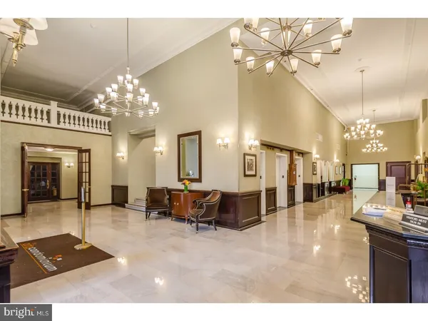 a lobby with furniture and a chandelier