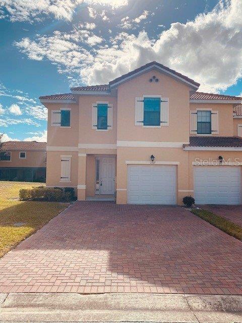 1367 Pacific Road Poinciana, FL 34759 - Photo 1 of 1 a front view of a house with a yard and garage