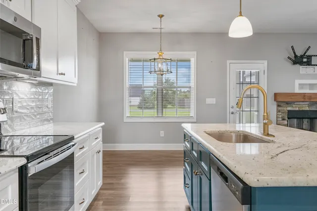 a kitchen with stainless steel appliances granite countertop a sink stove and cabinets