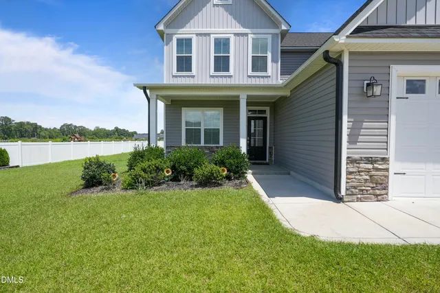 a front view of a house with a yard and lake view