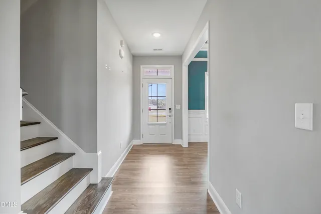 a view of a hallway with wooden floor and entryway