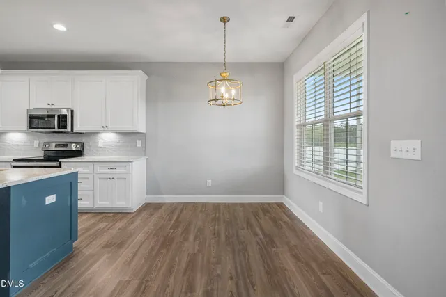 a kitchen with a wooden floor stove top oven and cabinets