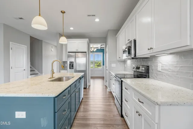 a kitchen with stainless steel appliances granite countertop a sink stove and refrigerator