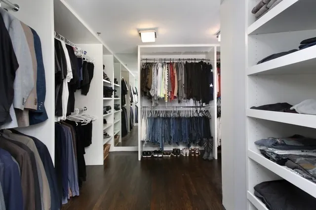 a view of walk in closet with clothes and shoes
