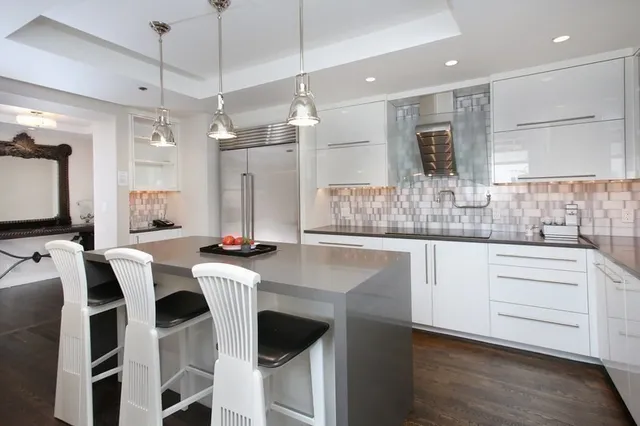 a kitchen with a dining table chairs sink and cabinets