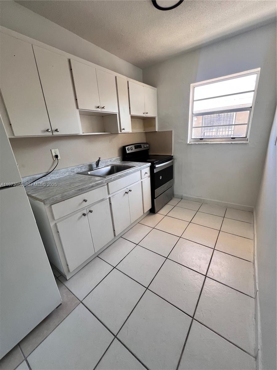 608 Southwest 15th Avenue, Unit 2 Miami, FL 33135 - Photo 9 of 22 a kitchen with stainless steel appliances granite countertop a sink and a stove