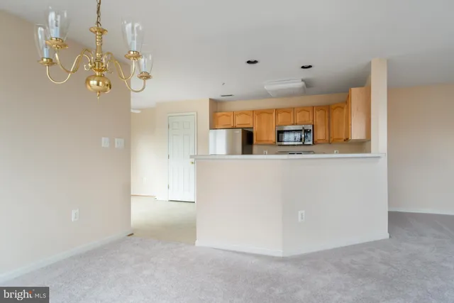 an empty room with chandelier fan and windows
