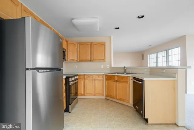 a kitchen with stainless steel appliances granite countertop a stove microwave and refrigerator