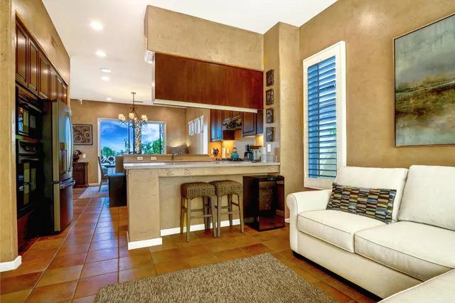 a living room with furniture a kitchen view and a fireplace