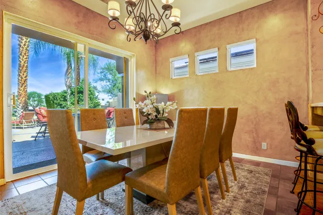 a view of a dining room with furniture a chandelier and wooden floor