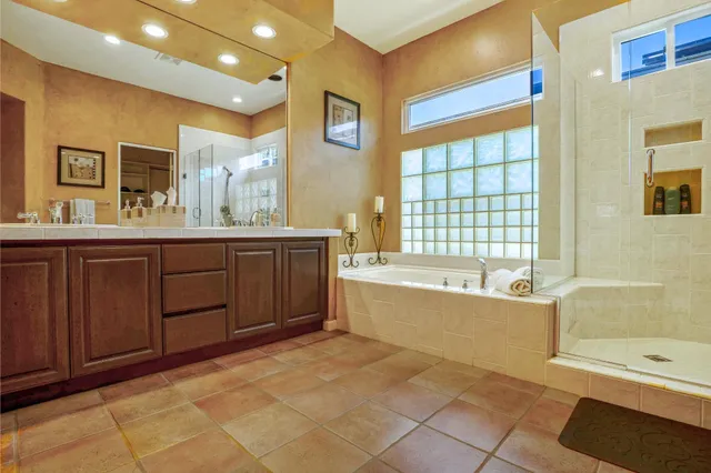 a spacious bathroom with a tub a sink and mirror