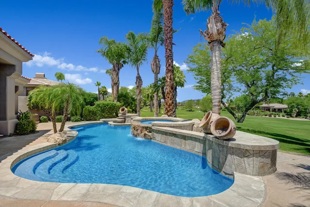 a swimming pool with outdoor seating yard and green space
