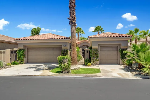 a front view of a house with a garden and plants