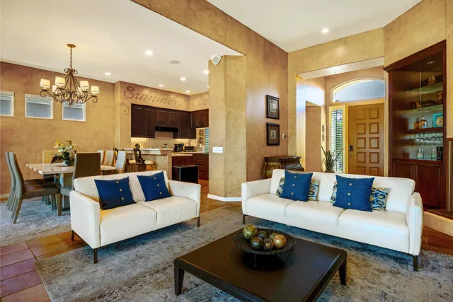a living room with furniture a rug and a chandelier