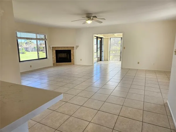 an empty room with windows and fireplace