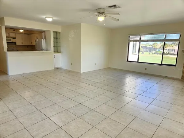 an empty room with windows and fan