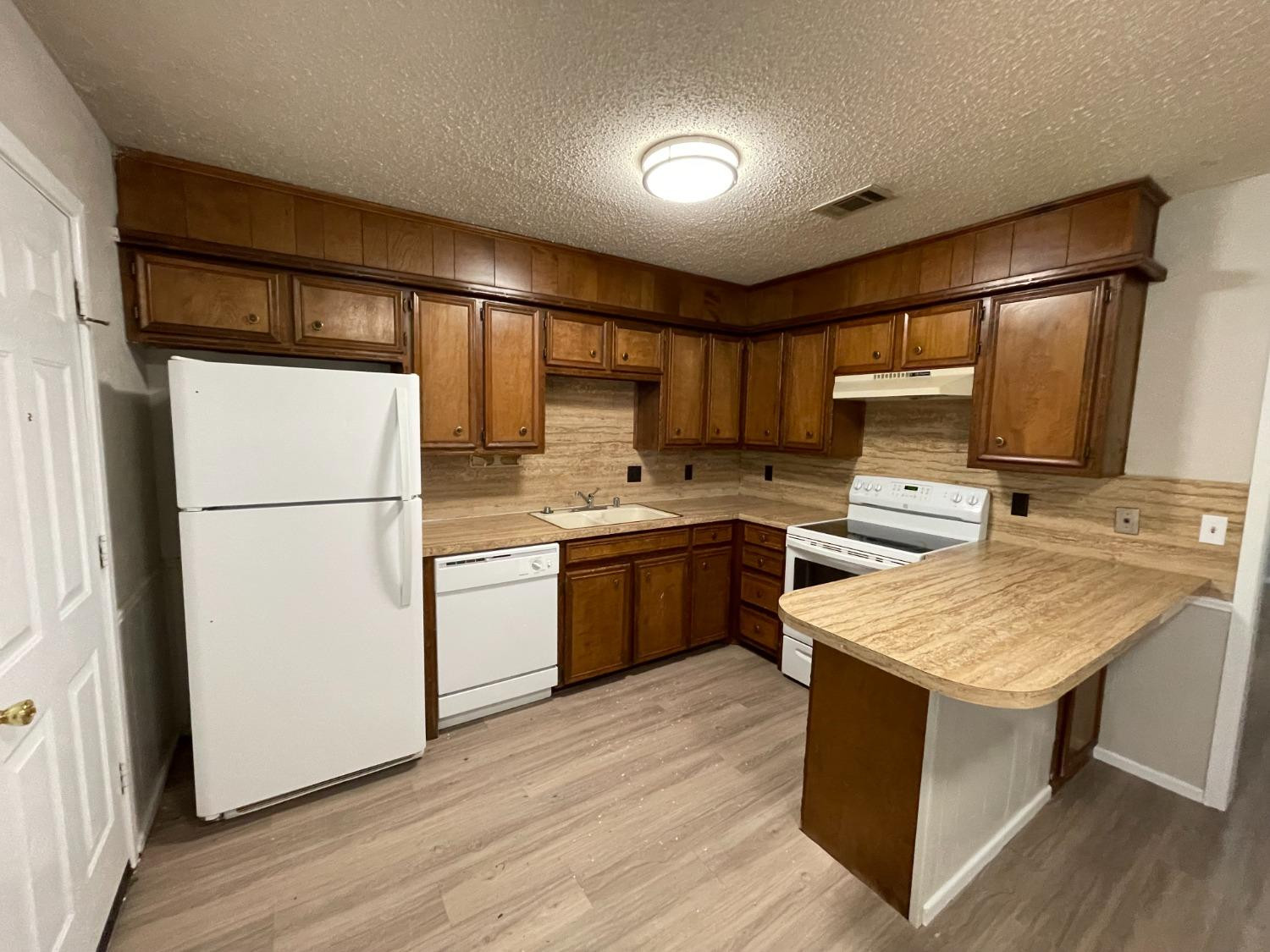 4812 66th Street, Unit B Lubbock, TX 79414 - Photo 3 of 9 a kitchen with a refrigerator sink and cabinets