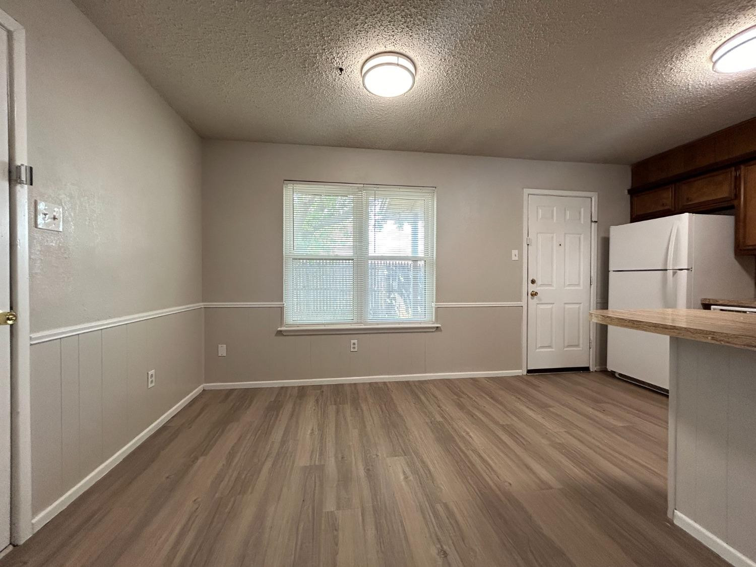 4812 66th Street, Unit B Lubbock, TX 79414 - Photo 4 of 9 wooden floor in an empty room with a window