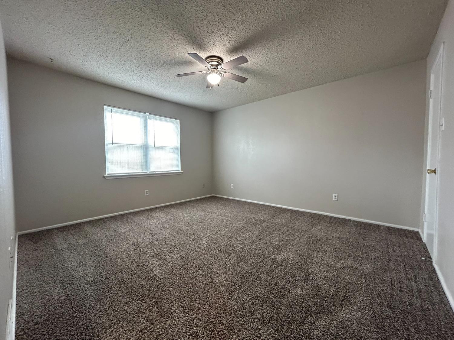 4812 66th Street, Unit B Lubbock, TX 79414 - Photo 8 of 9 an empty room with windows and fan