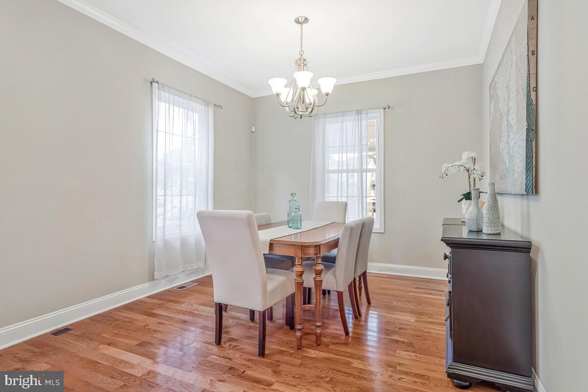 4037 7th Street North Beach, MD 20714 - Photo 15 of 54 a view of a dining room with furniture a chandelier and wooden floor
