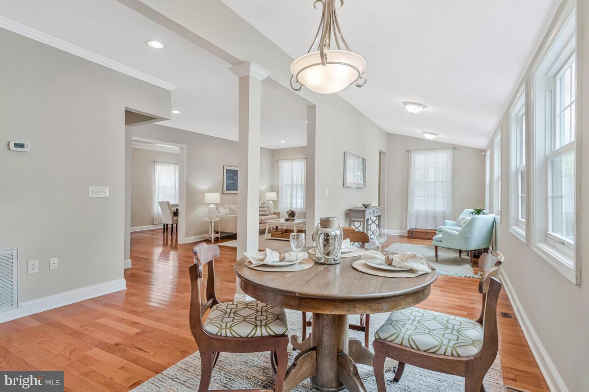 4037 7th Street North Beach, MD 20714 - Photo 26 of 54 a view of a dining room and livingroom with furniture wooden floor a chandelier
