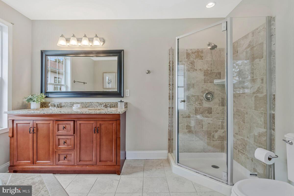 4037 7th Street North Beach, MD 20714 - Photo 37 of 54 a bathroom with a granite countertop sink a mirror and a shower