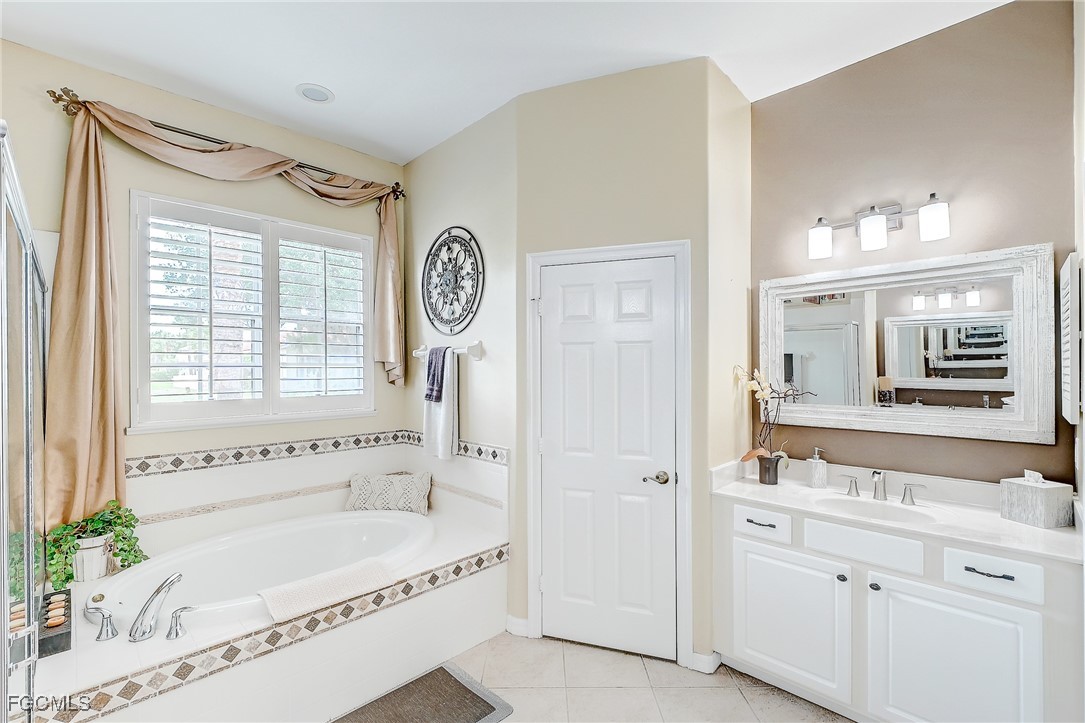 12890 Timber Ridge Drive Fort Myers, FL 33913 - Photo 22 of 39 a bathroom with a tub a sink and a large mirror