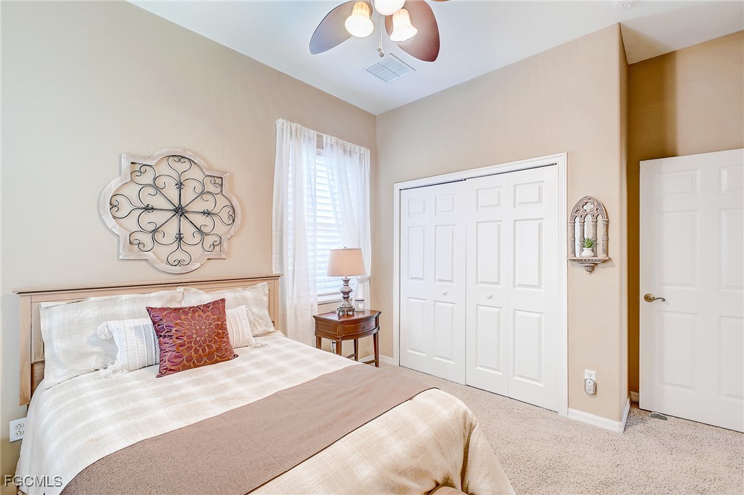 12890 Timber Ridge Drive Fort Myers, FL 33913 - Photo 25 of 39 a bedroom with a bed and a chandelier