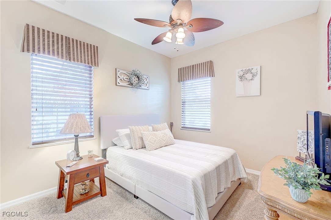 12890 Timber Ridge Drive Fort Myers, FL 33913 - Photo 26 of 39 a bedroom with a bed and a chandelier