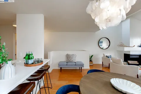 a living room with furniture a chandelier and a dining room