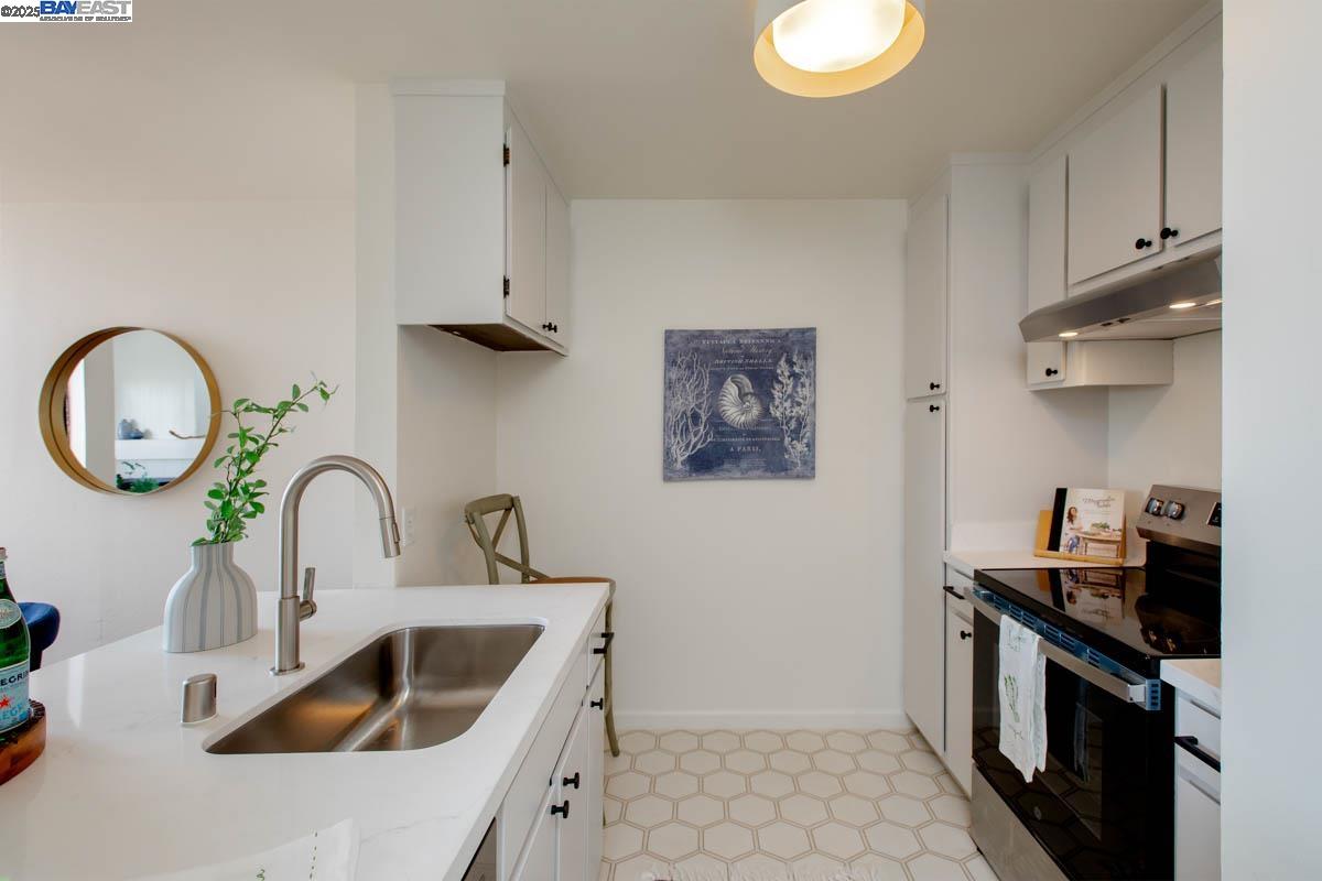 2101 Shore Line Drive, Unit 475 Alameda, CA 94501 - Photo 23 of 37 a kitchen with a sink and a stove with wooden floor