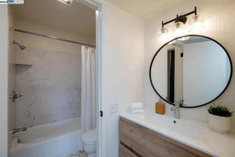 a bathroom with a sink mirror bathtub and toilet