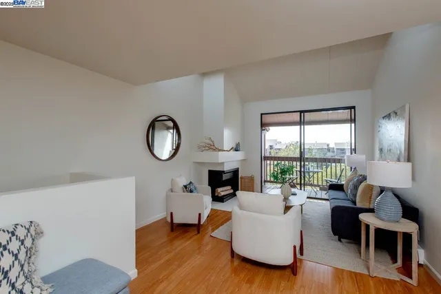 a living room with furniture a fireplace a flat screen tv and a large window