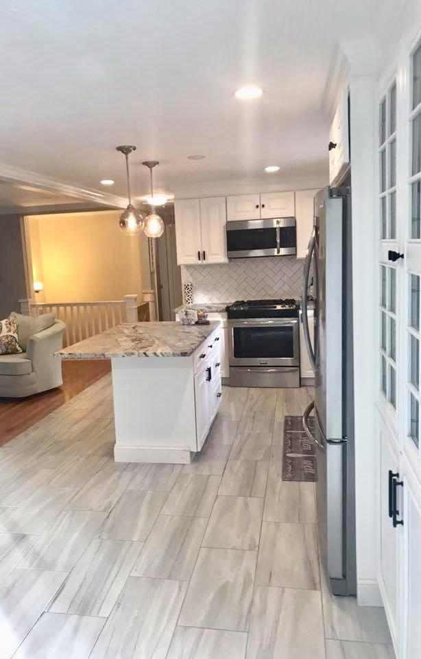 57 Anchor Lane Cotuit, MA 02635 - Photo 5 of 29 a large white kitchen with kitchen island a large counter top space a sink stainless steel appliances and cabinets