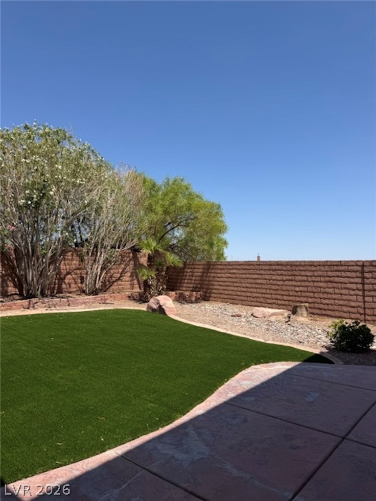 3862 Landing Ridge Place Las Vegas, NV 89135 - Photo 25 of 26 A private backyard oasis showcases lush artificial turf and a shaded patio for outdoor leisure.
