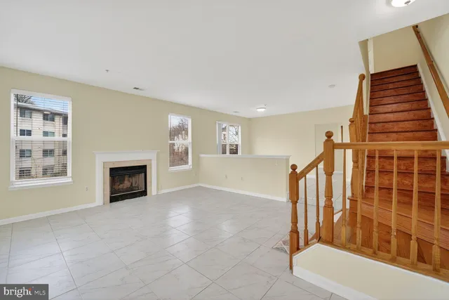 a view of an empty room with a fireplace and a window