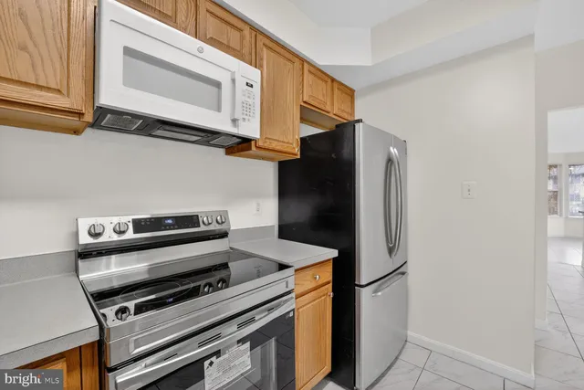 a kitchen with stainless steel appliances a refrigerator a stove and cabinets
