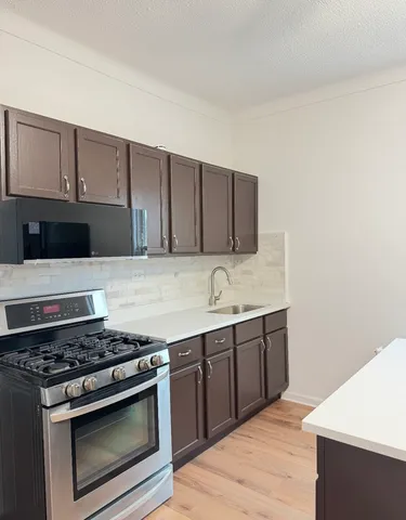 a kitchen with wooden cabinets and a stove top oven