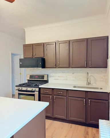 a kitchen with wooden cabinets and white appliances