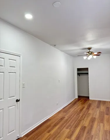 a view of empty room with wooden floor