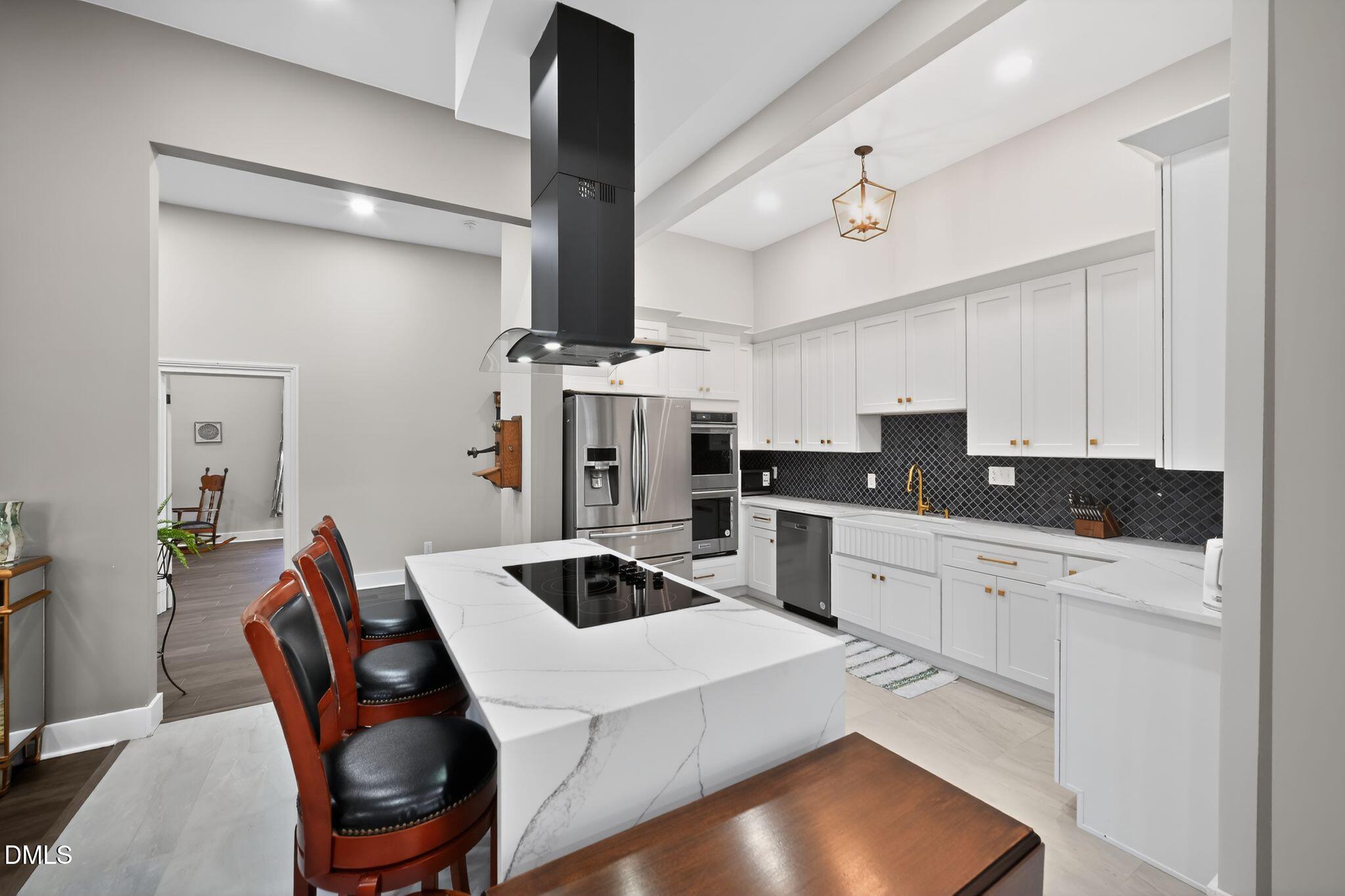 6325 Whitted Road Fuquay-Varina, NC 27526 - Photo 20 of 57 a kitchen with stainless steel appliances kitchen island granite countertop a stove a sink a refrigerator and white cabinets