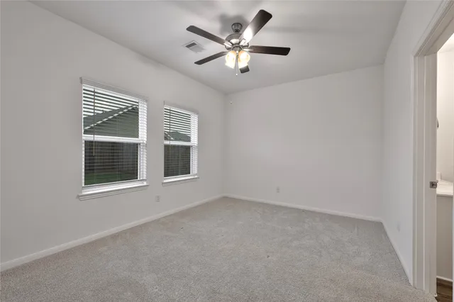 an empty room with a window and a ceiling fan