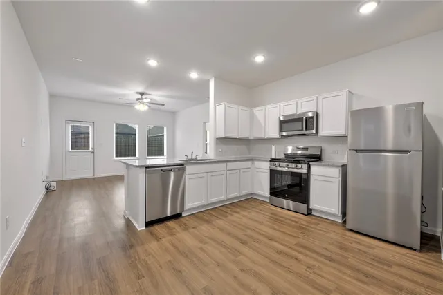 a kitchen with granite countertop a refrigerator and a stove top oven