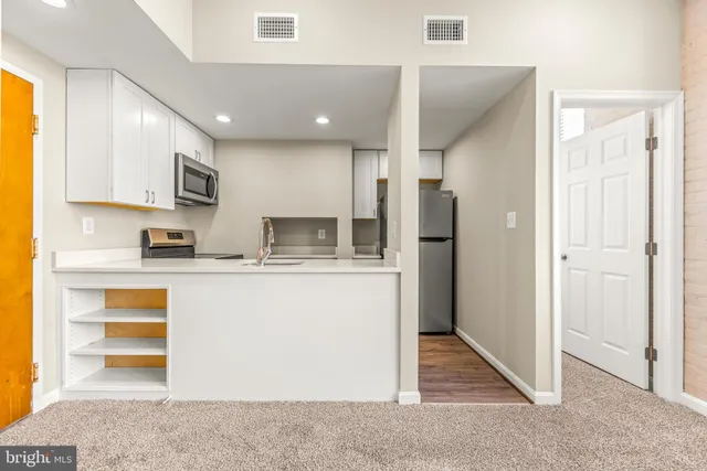 a kitchen with stainless steel appliances granite countertop a refrigerator and a stove