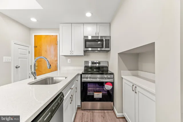 a kitchen with a sink a stove and cabinets